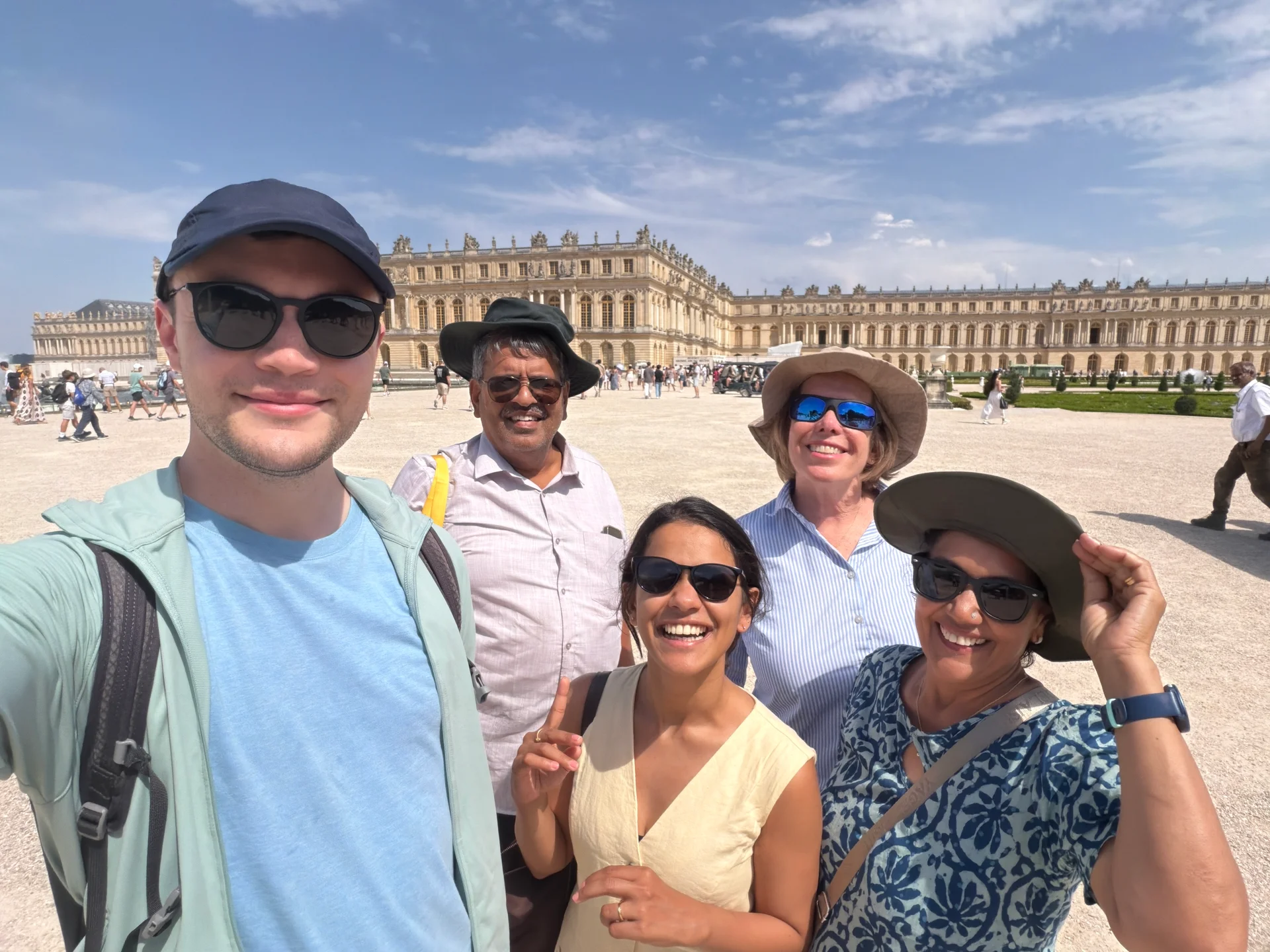 The whole group posing in front of the Palace of Versailles in the heat